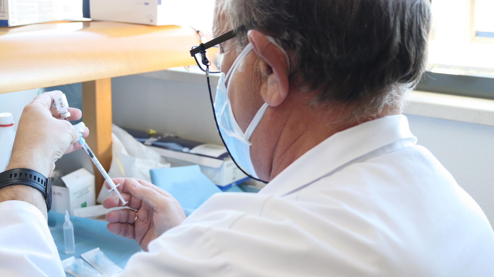 Un enfermero prepara una vacuna.