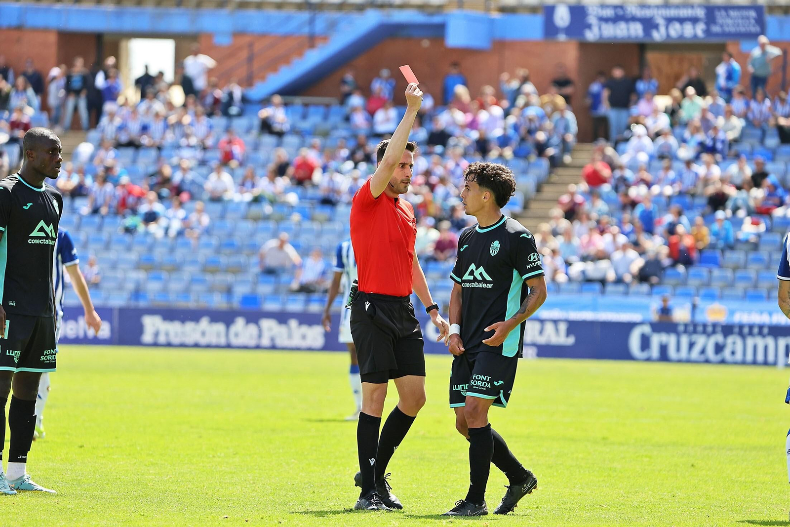 El colegiado le muestra la tarjeta roja a David Navarro.