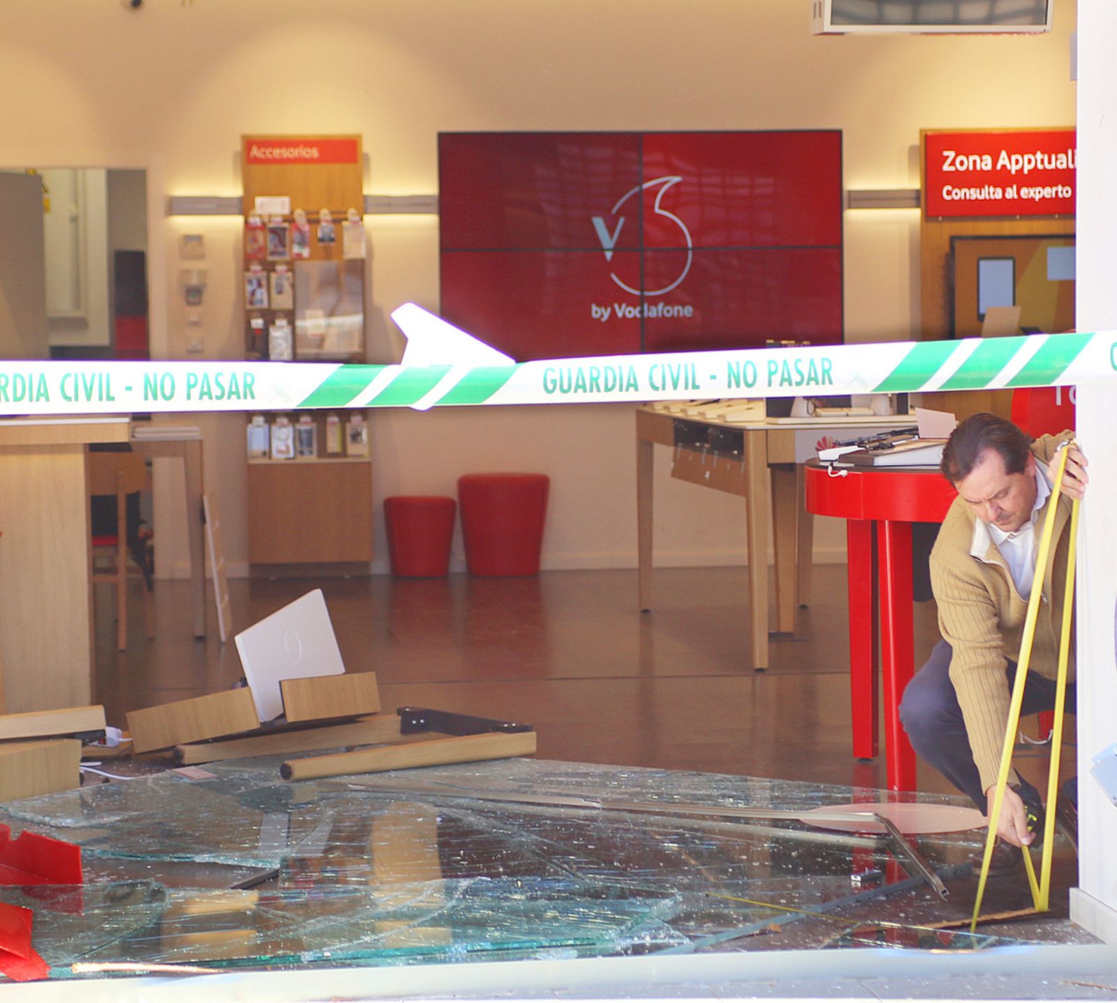 Imagen del escaparate destrozado y precintado.