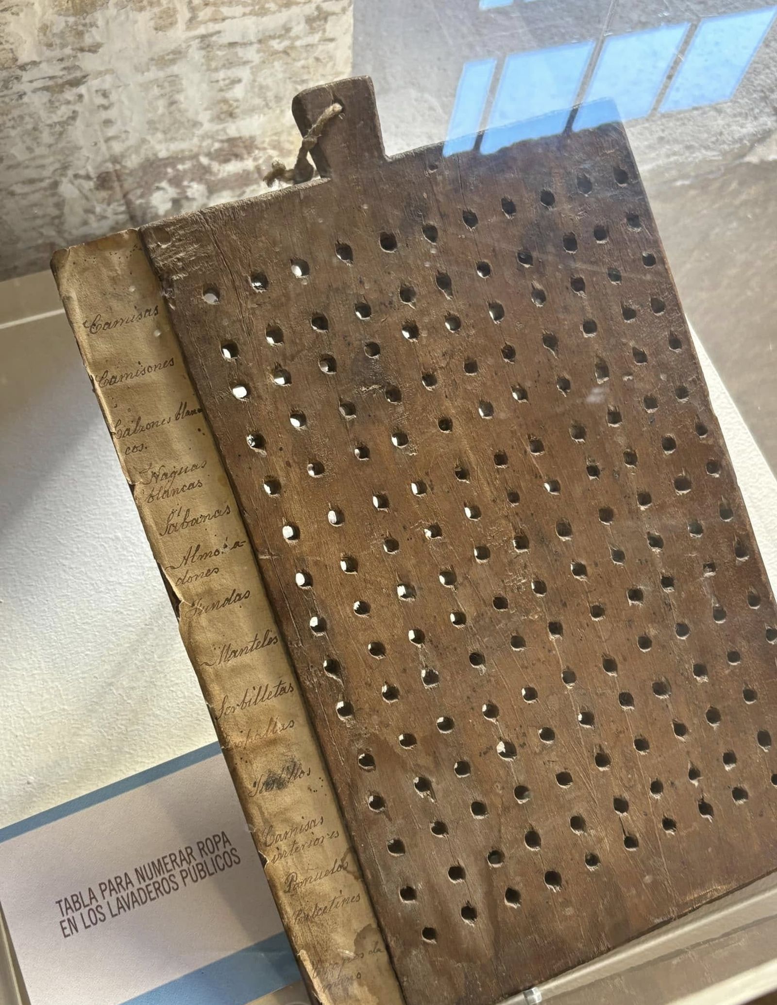 Tabla original para numerar la ropa en los lavaderos públicos, una pieza histórica que ilustra la organización y disciplina del sistema de beneficencia de la Diputación Provincial de Jaén en el siglo XIX.
