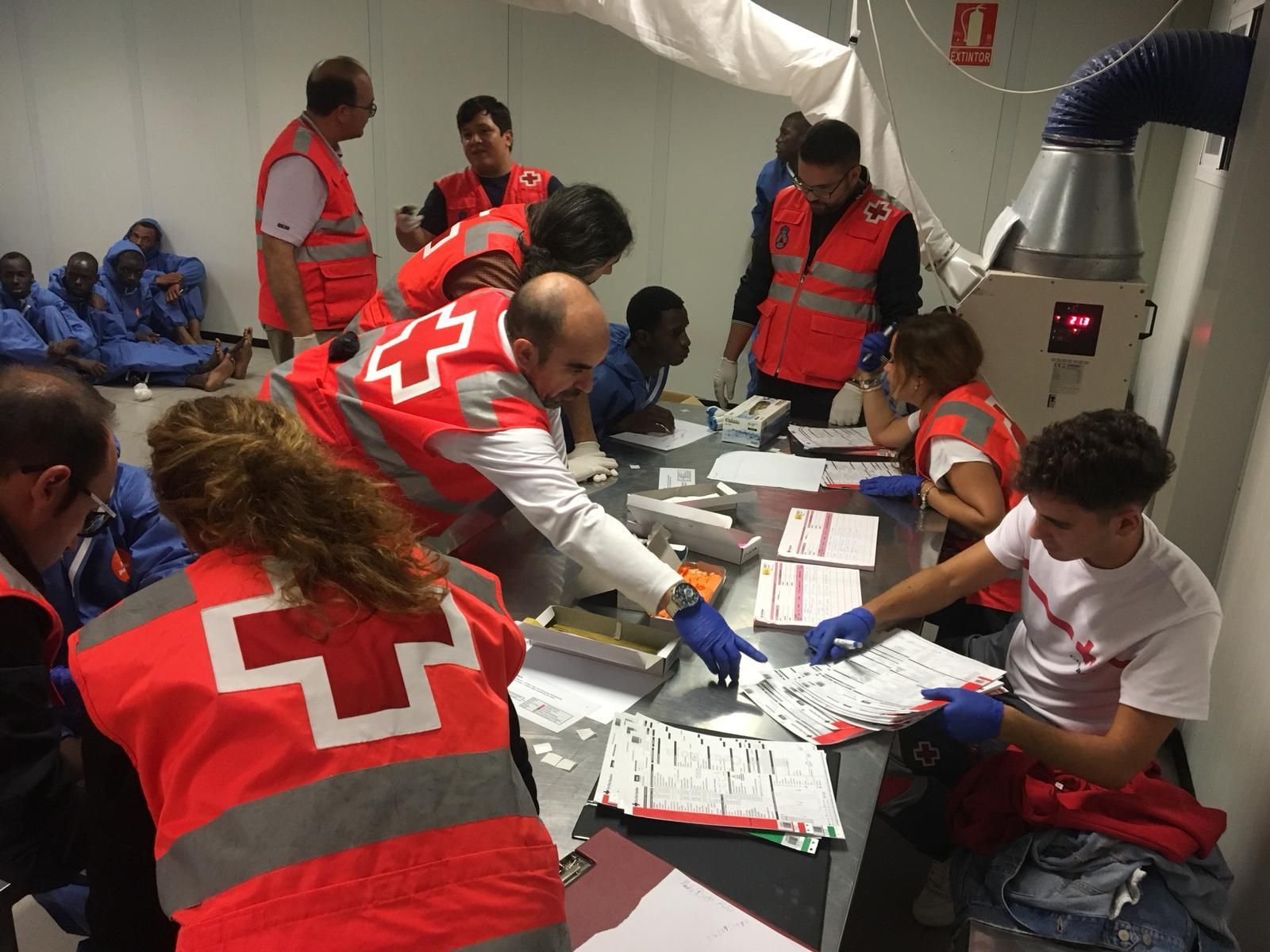 Voluntarios de Cruz Roja atienden a inmigrantes en el CATE del Puerto de Almería