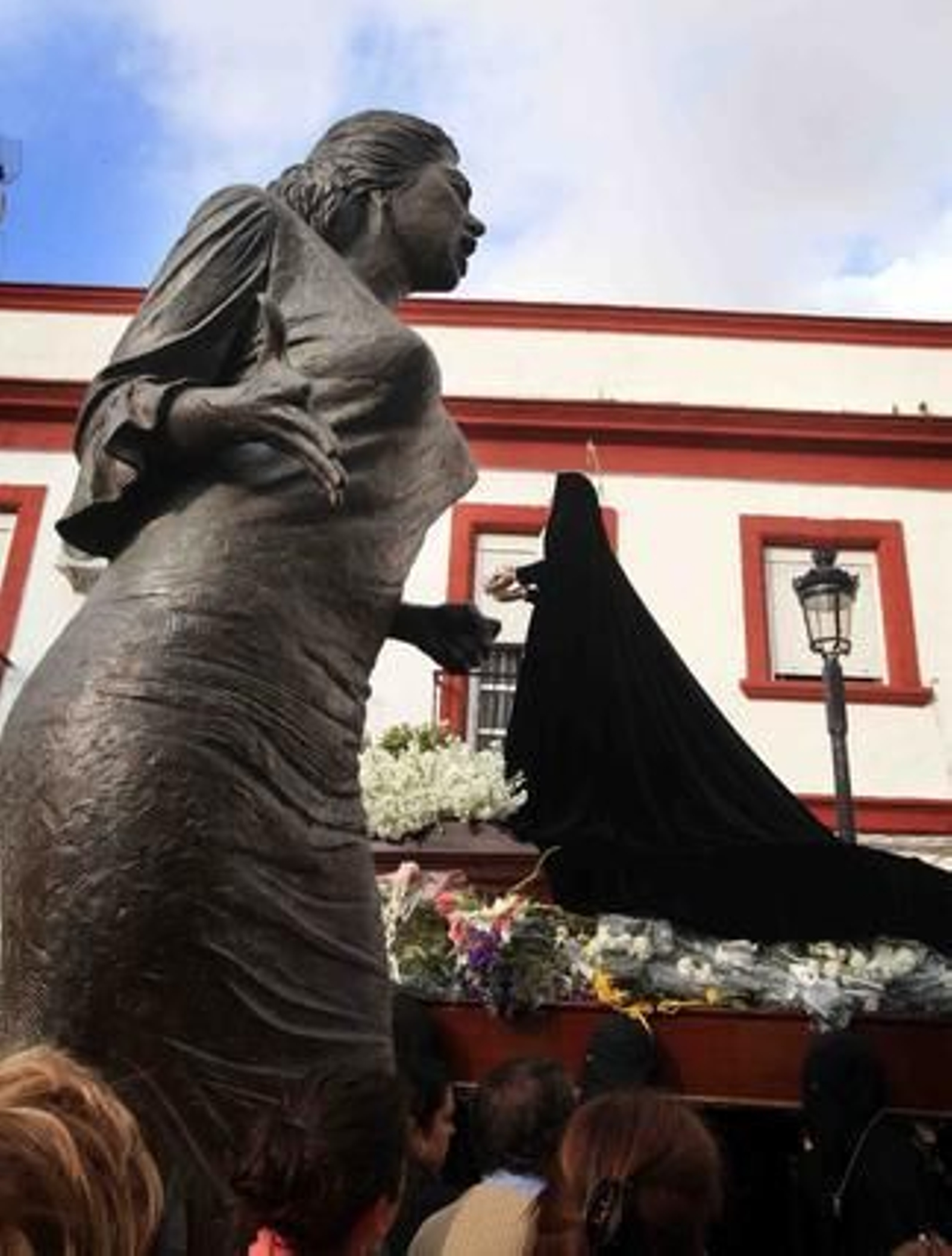 Frente a frente. Las andas de Amor y Sacrificio pasan ante el monumento a La Paquera de Jerez en la Cruz Vieja.

Foto: Vanesa Lobo