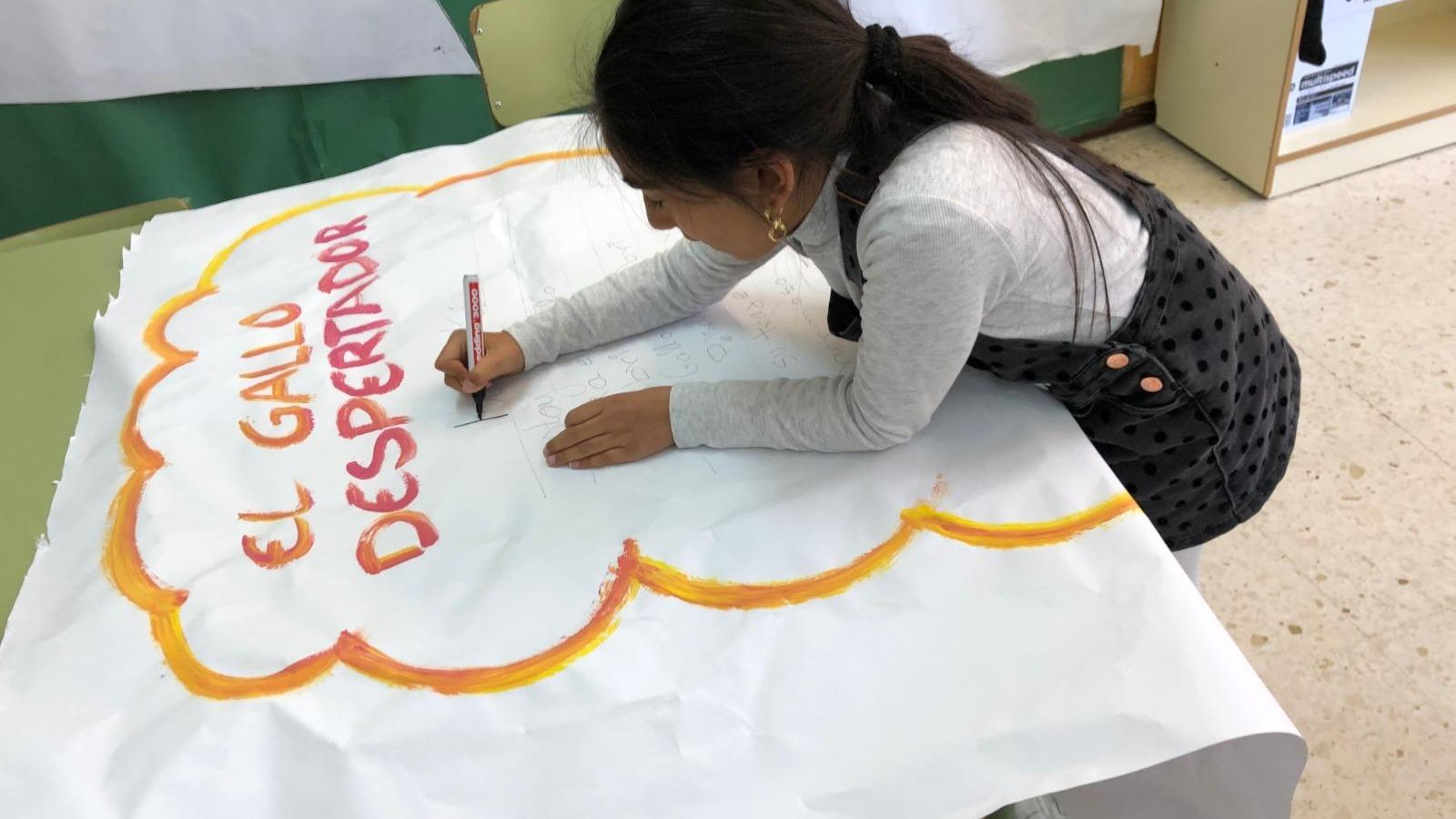 Una alumna dibuja un cartel