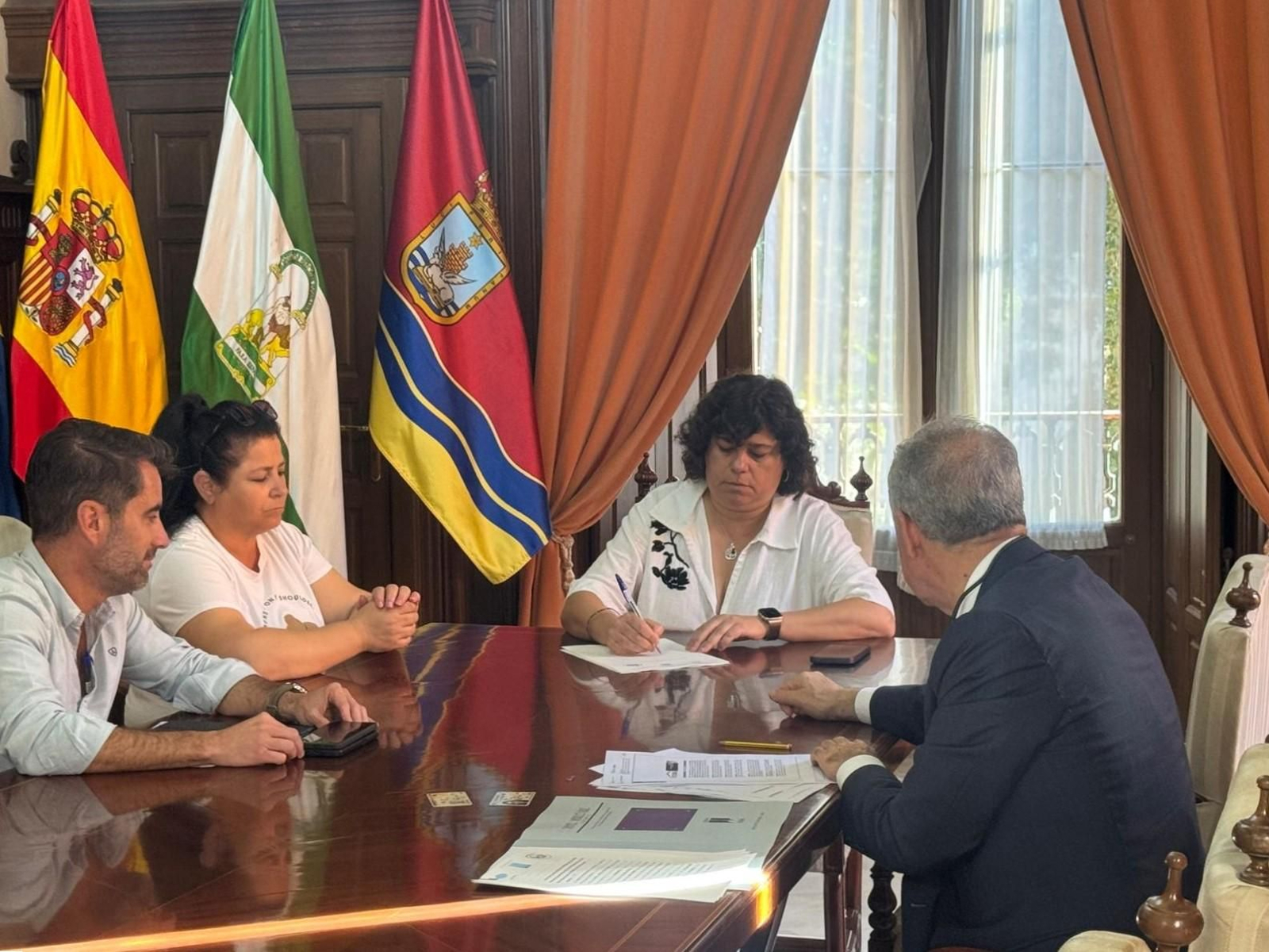 Carmen Álvarez firma las escrituras de las viviendas en la barriada El Palomar y La Dehesilla.