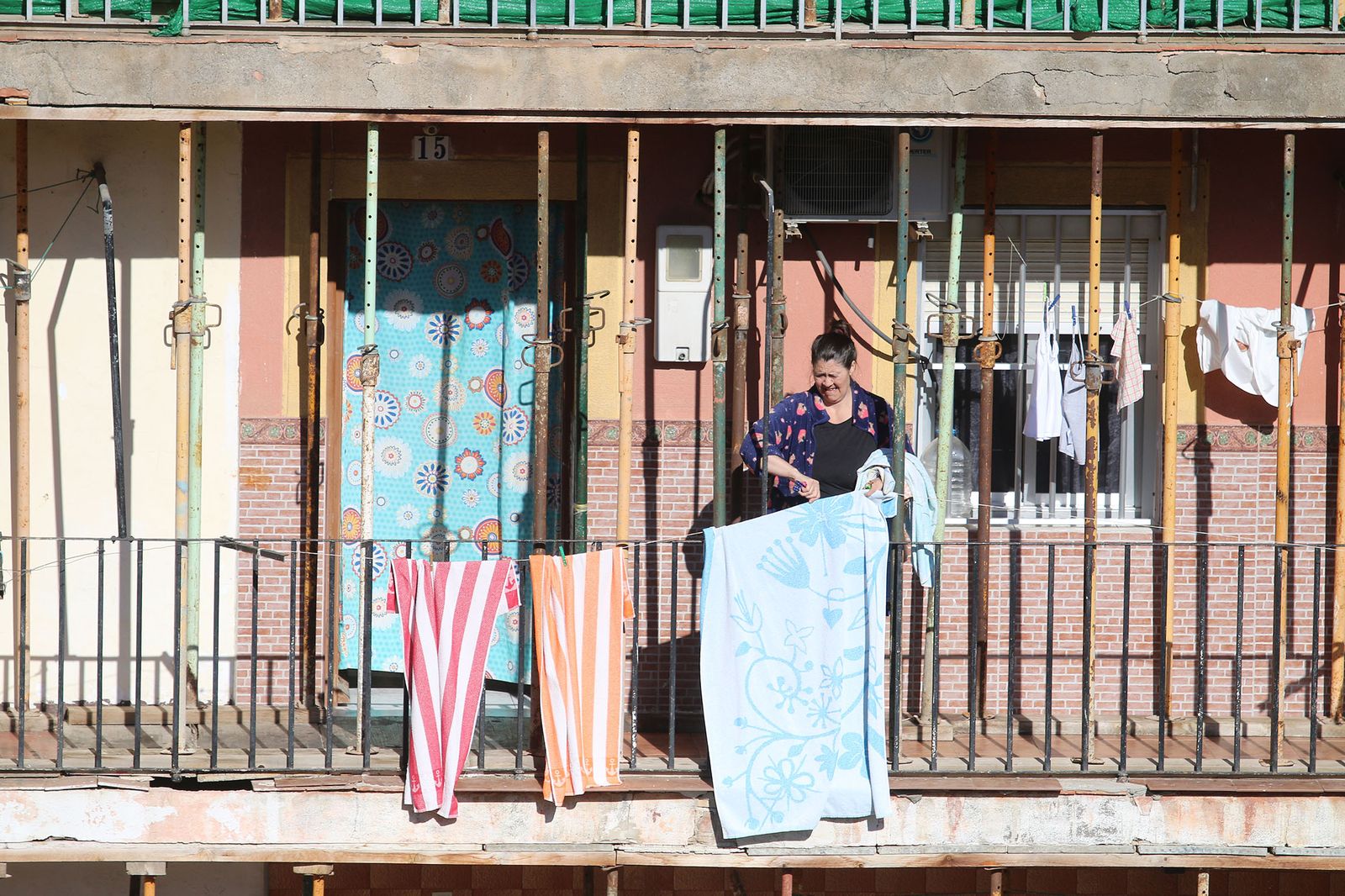 Una mujer tiende toallas entre puntales.