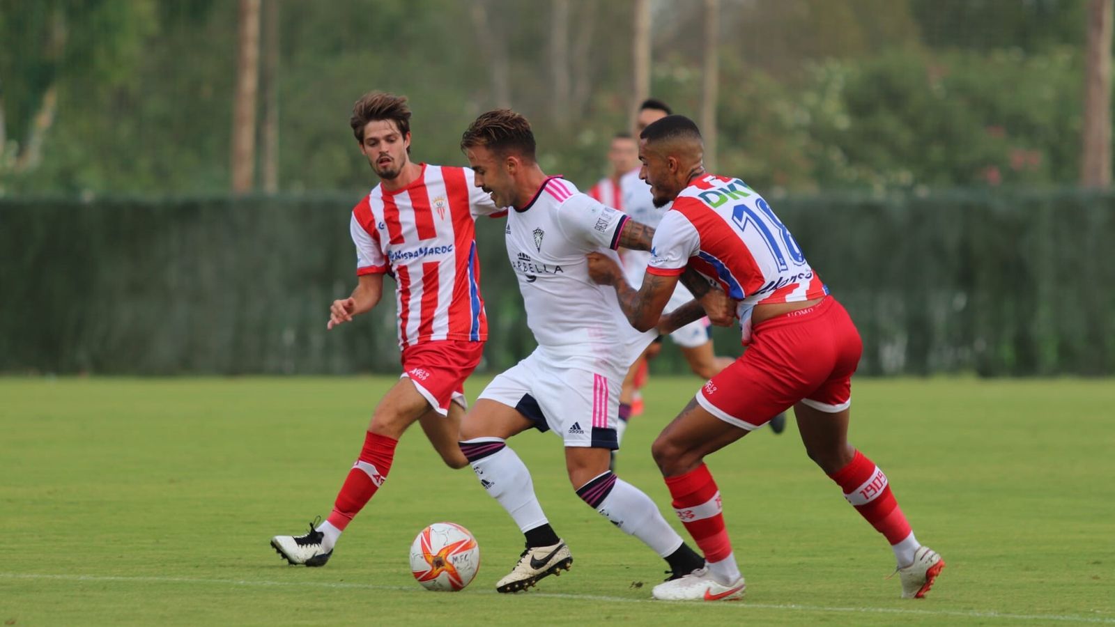 Robin y Duarte intentan robar un balón a un jugador del Marbella.