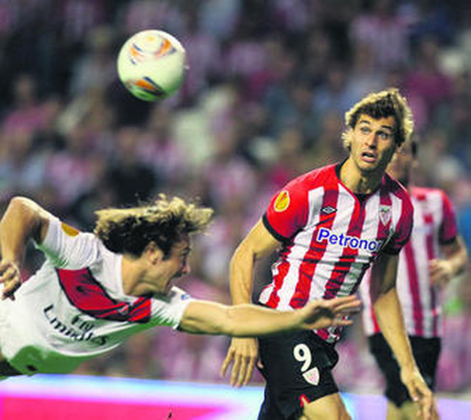 Lugano intenta evitar el remate de Llorente.