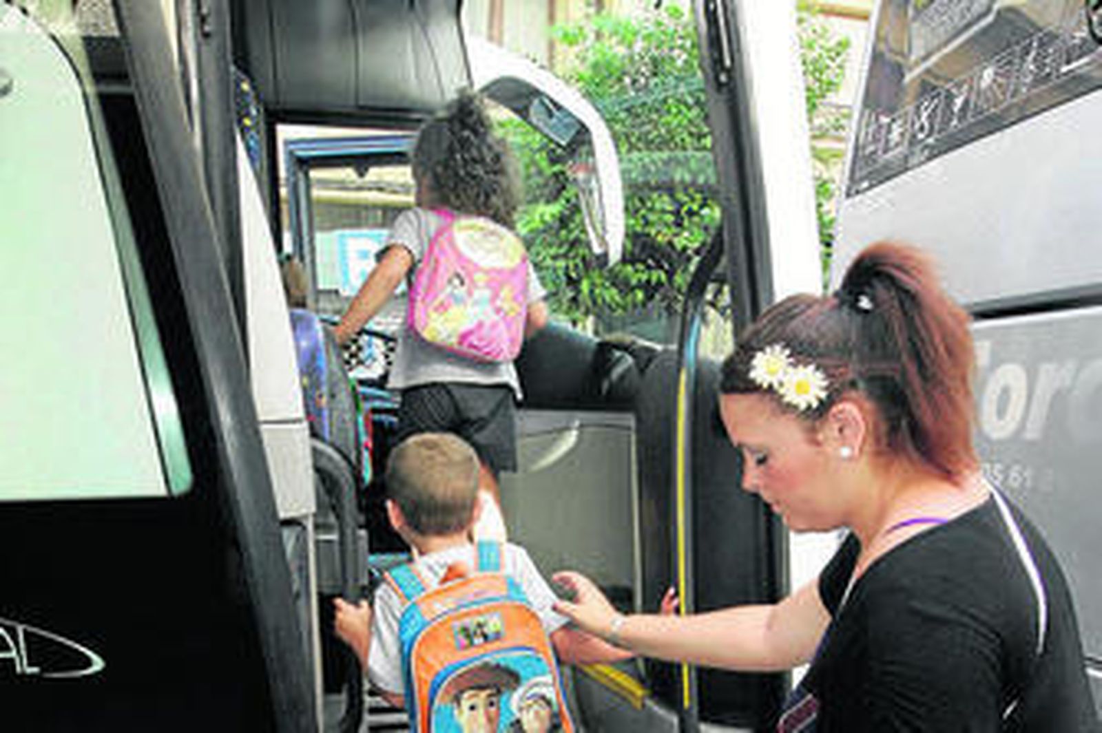 Varios niños suben a un autobús escolar.