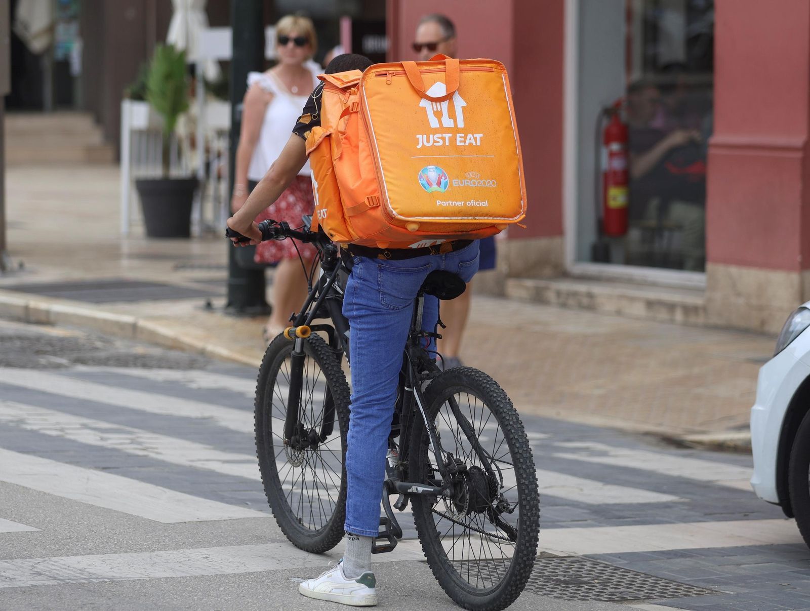 Un repartidor de la plataforma mientras lleva  un pedido.