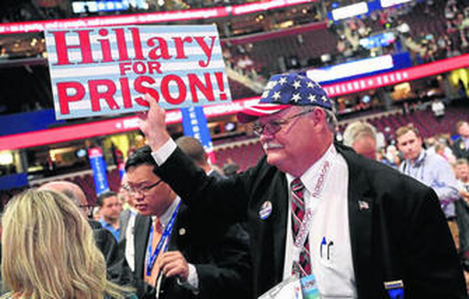Un simpatizante de Donald Trump muestra un cartel contra Clinton en la Convención Republicana.