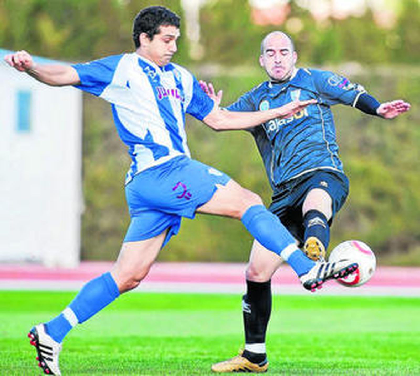 Óscar Ventaja trata de tocar el balón ante la llegada de un jugador del Jumilla.