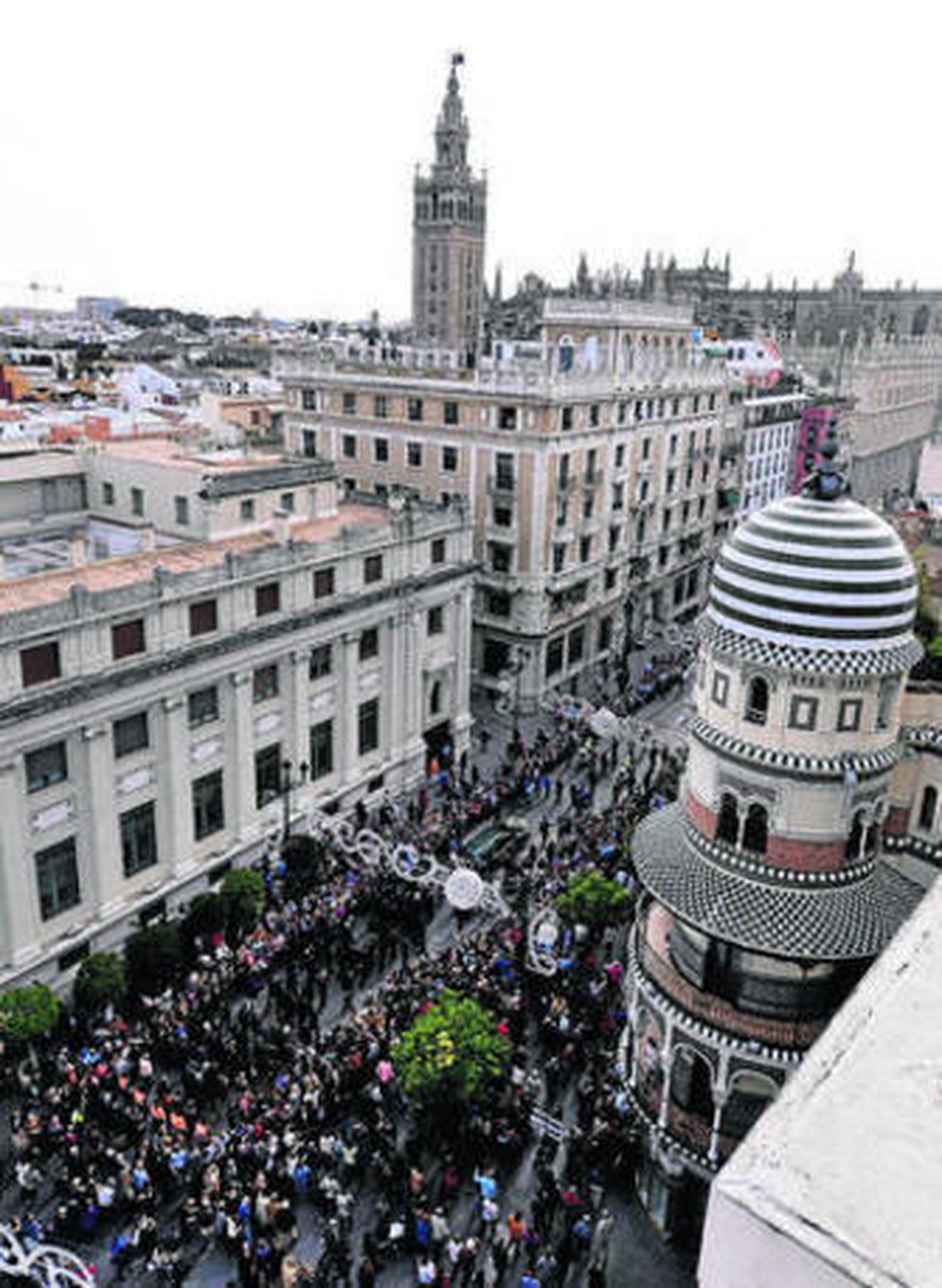 El cortejo fúnebre avanza por la Avenida, con la Giralda al fondo.