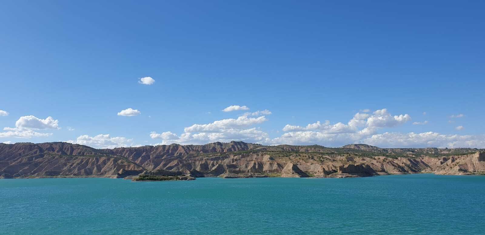 Uno de los paisajes del Geoparque: 'badland' en Cuevas del Campo desde la playa de Freila, en el pantano del Negratín