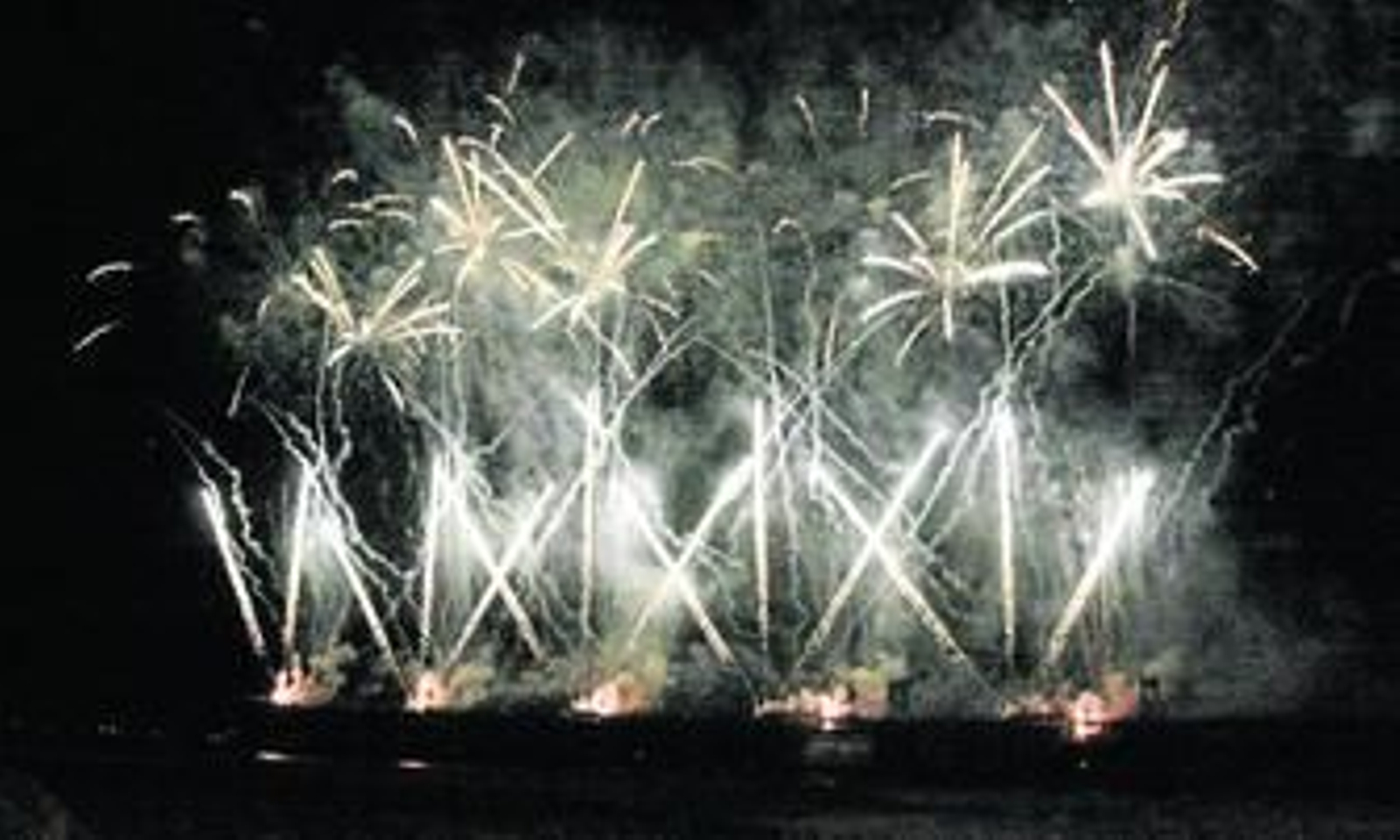 1. Momento del castillo de fuegos artificiales del fin de fiesta del pasado año, preparado también por la empresa Pirotecnia Ricardo Caballer. 2. Muelle de mineral de la compañía de Río Tinto, comúnmente conocido como Muelle del Tinto, ayer por la mañana, durante la segunda jornada de montaje del espectáculo de fuegos de artificio. 3. Uno de los trabajadores de la empresa Pirotecnia, durante la preparación de los morteros y las carcasas. 4. Un trabajador conecta los cables de los distintos módulos para luego enlazarlos todos mediante una manguera y conectarlos con los ordenadores. 5. Durante la mañana de ayer, dos de los trabajadores tapando las bocas de los morteros con papel de aluminio para que al explosionar unas no interfiera en las demás adyacentes. 6. Los doce trabajadores que están preparando el espectáculo de Huelva. 7. Uno de los trabajadores insertando en los morteros las carcasas que se convertirán en luces de colores en el cielo onubense.