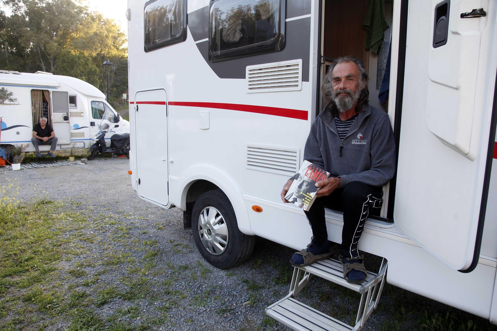 Un extranjero confinado muestra su novela 'La peste'.