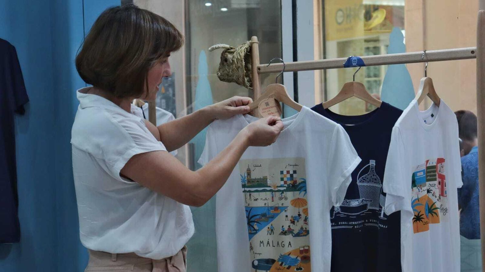 Ester Ramos, colocando unas camisetas en el escaparate.
