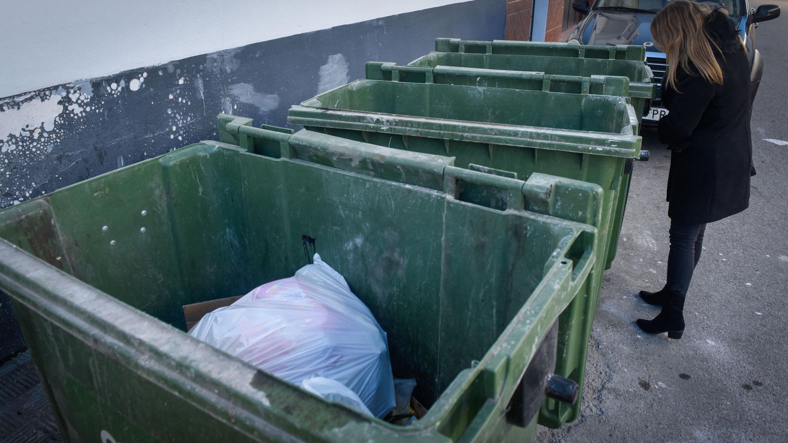 Una periodista observa los contenedores en los que apareció la menor.
