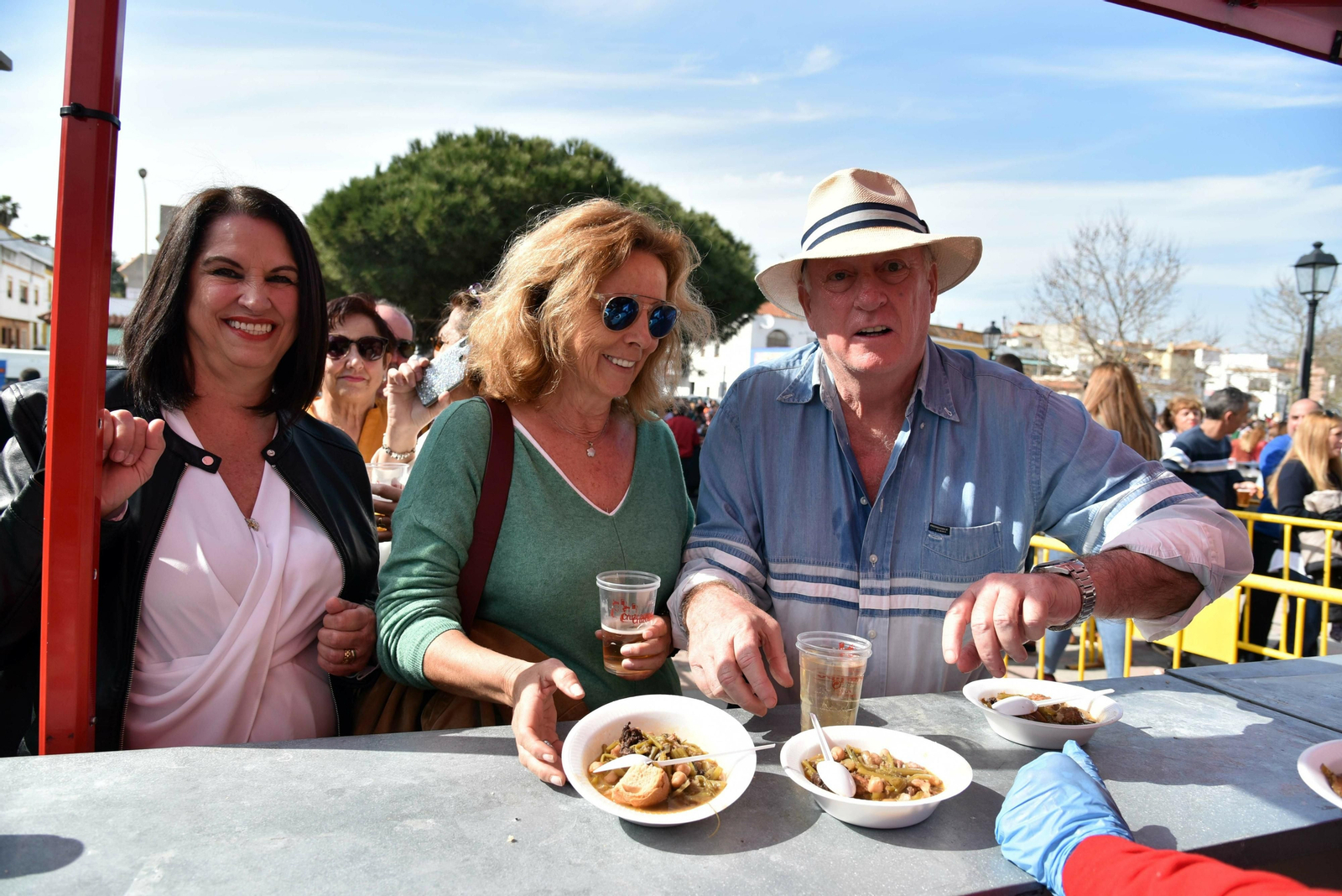 Tres personas recogen platos con el guiso de tagarninas en la edición de 2019.
