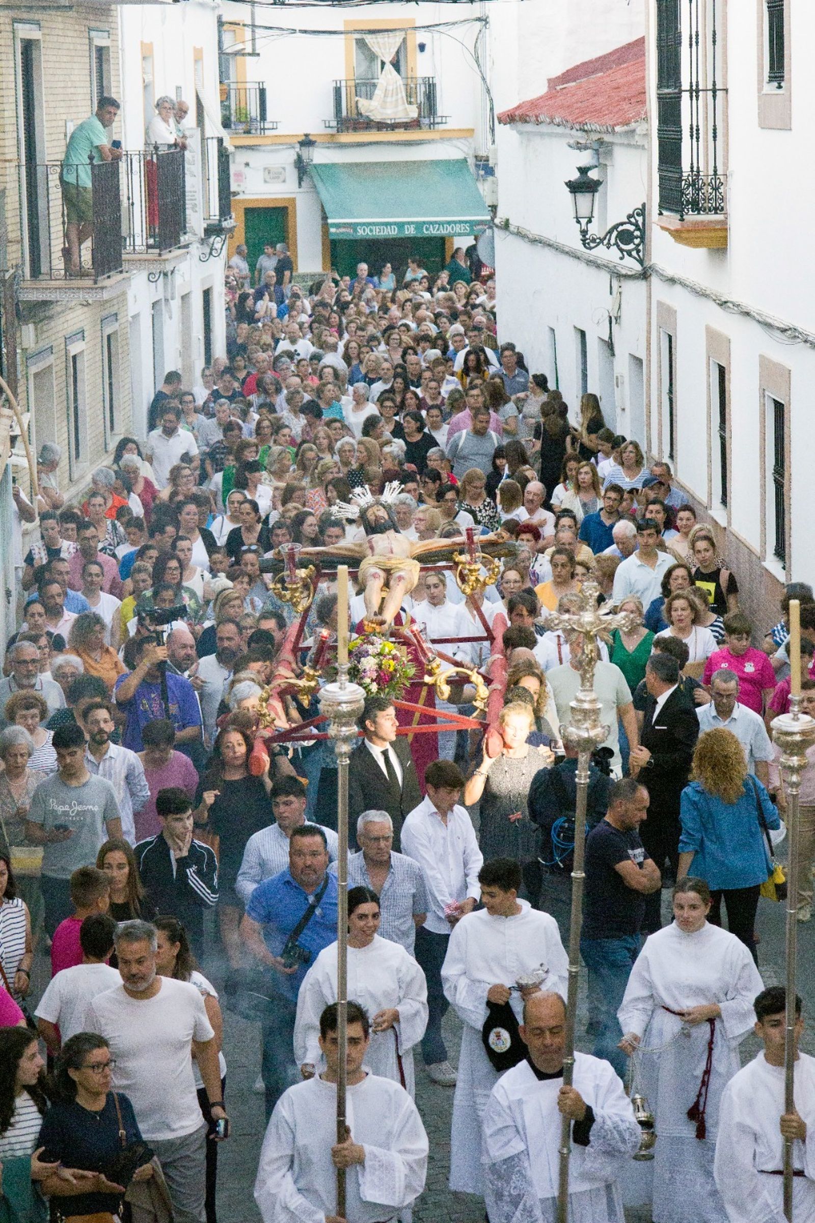La calle Sevilla, repleta de fieles acompañando al antiquísimo crucifficado.