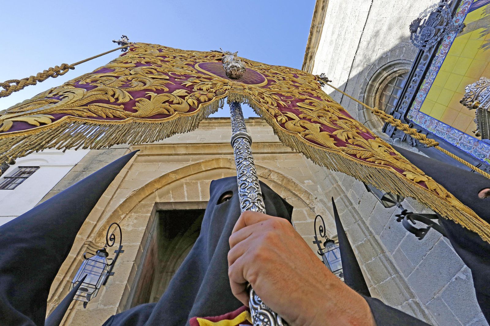 Un nazareno de las Tres Caídas porta en la salida procesional de ayer un estandarte mariano.