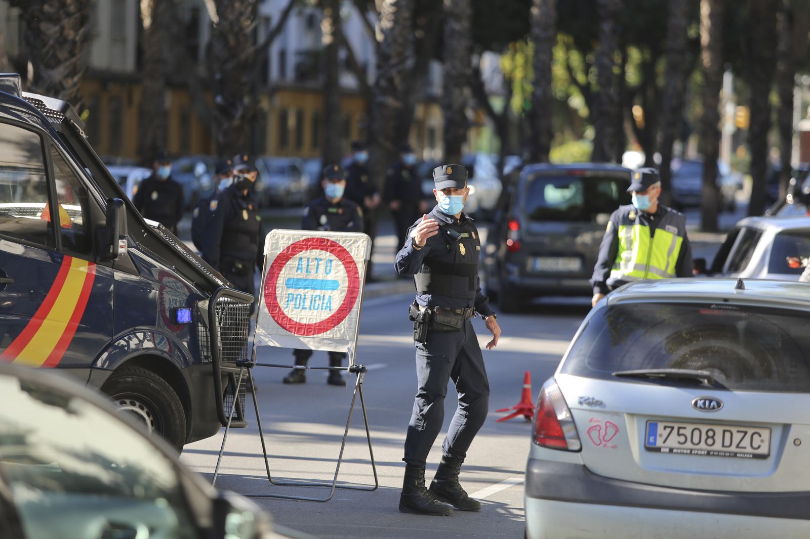 Un agente de la Policía Nacional efectúa labor de control de las salidas de los vehículos en Málaga.