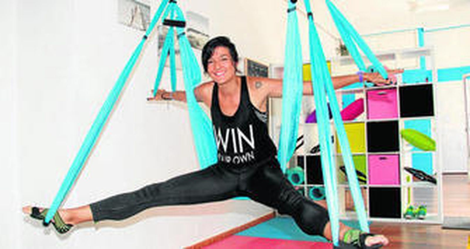 1. La monitora Lucía Fernández practica pilates aéreo en un colorido columpio. 2. Lucía Fernández con los socios del centro Carlos Peris y María José Castro. 3. Las instalaciones son diáfanas pero llenas de colores alegres que buscan la motivación.