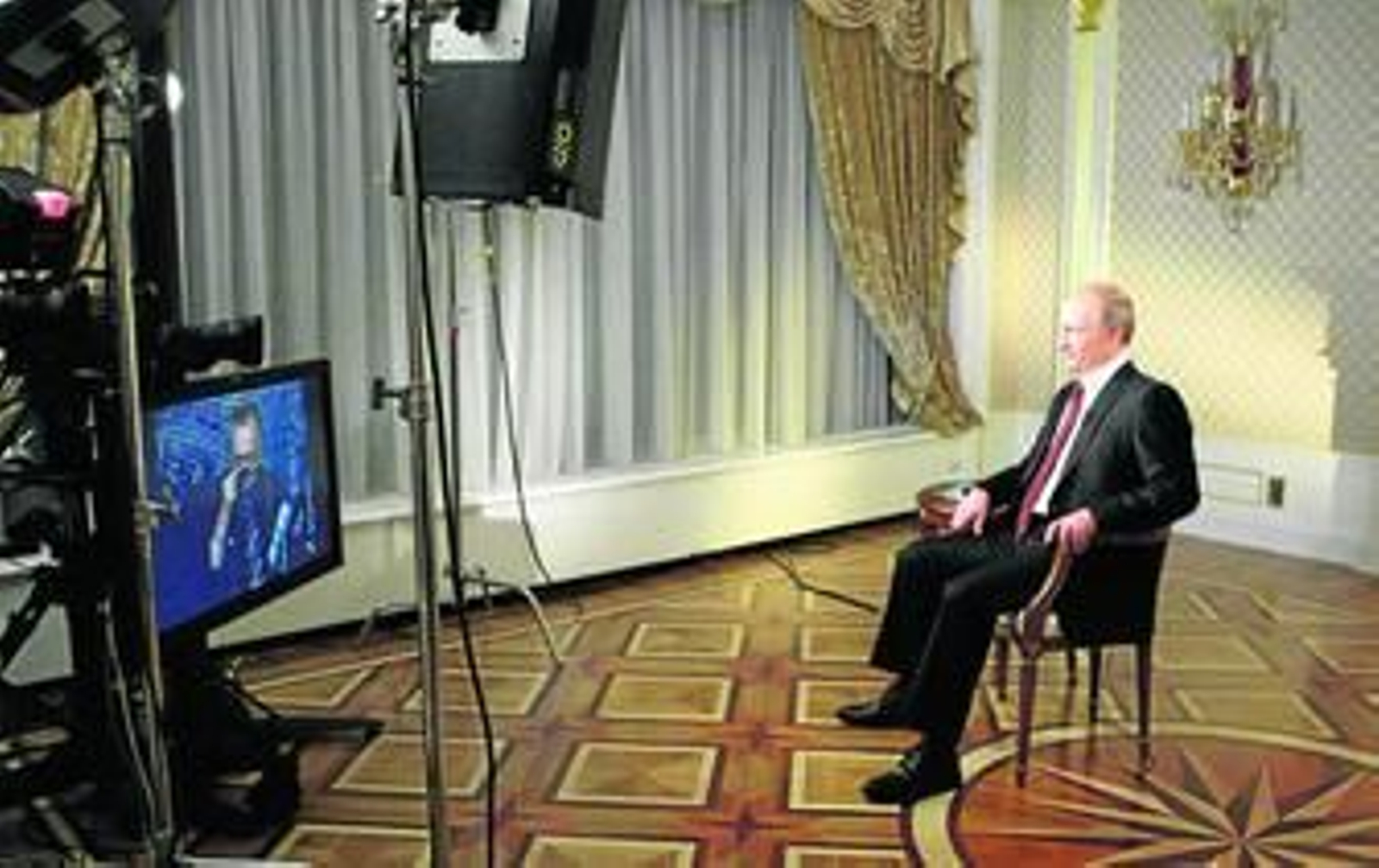El primer ministro ruso, Vladimir Putin, durante la entrevista con Larry King (en la pantalla) en Moscú.