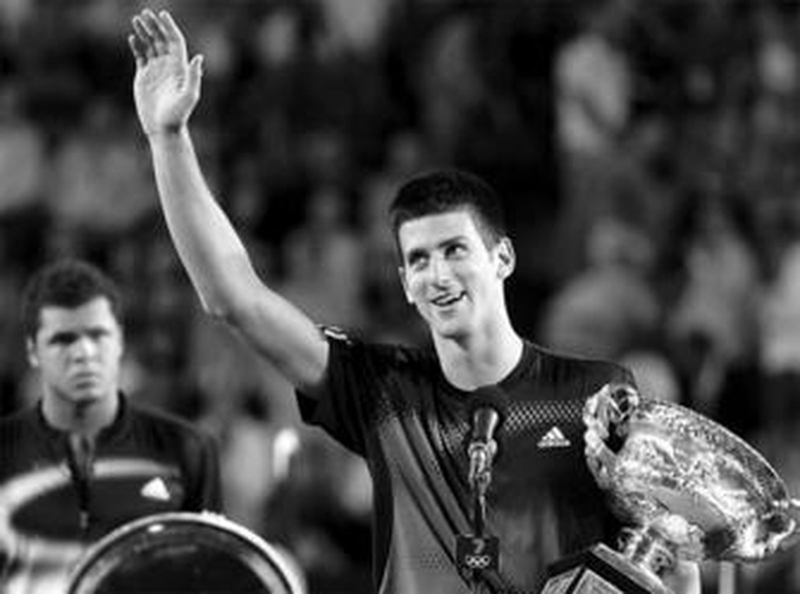 Djokovic festeja el título mientras que atrás, cabizbajo, Tsonga asiste con su trofeo en las manos.