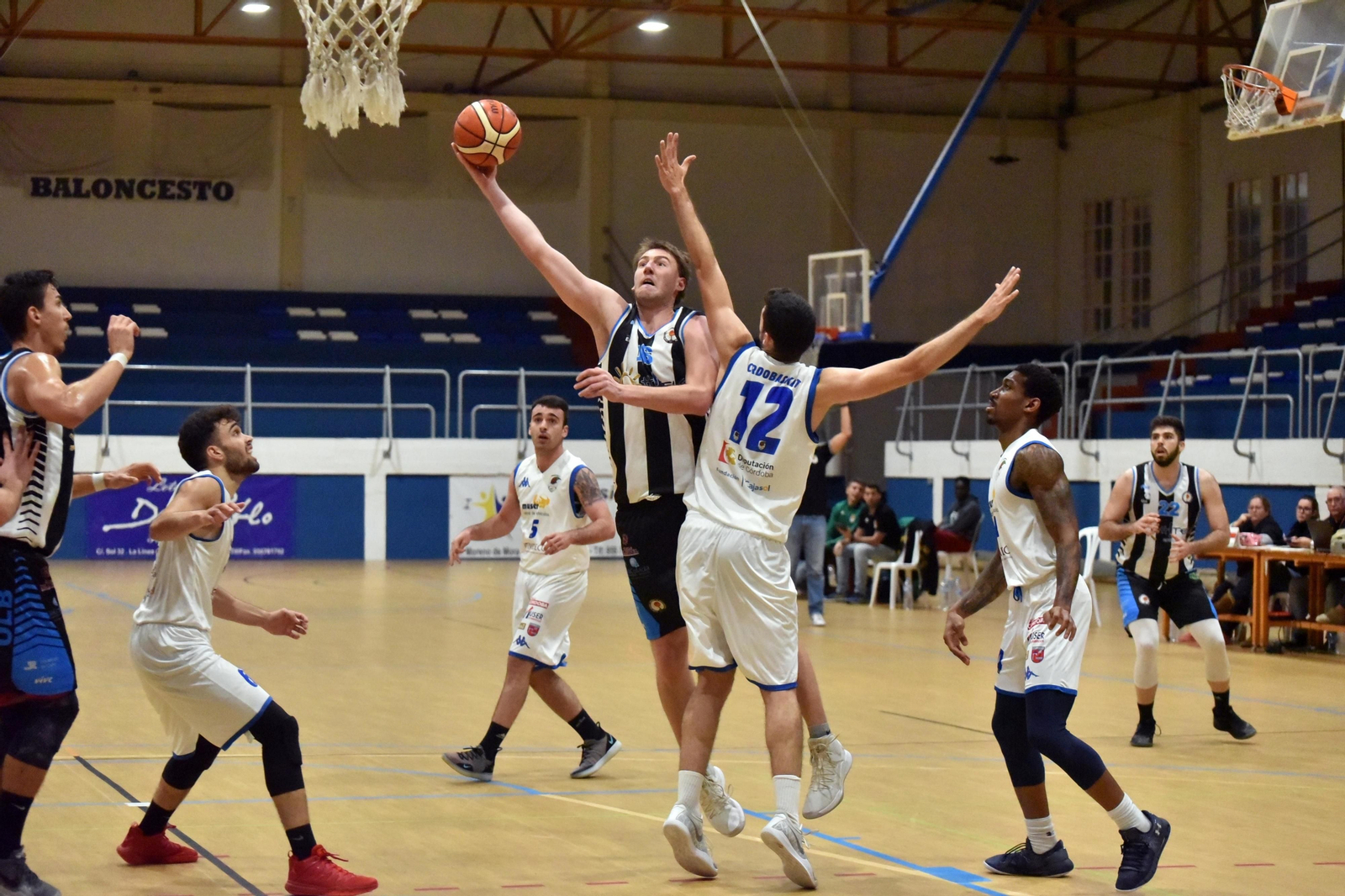 Jakub Kasa lanza a canasta ante la oposición de Ángel López.