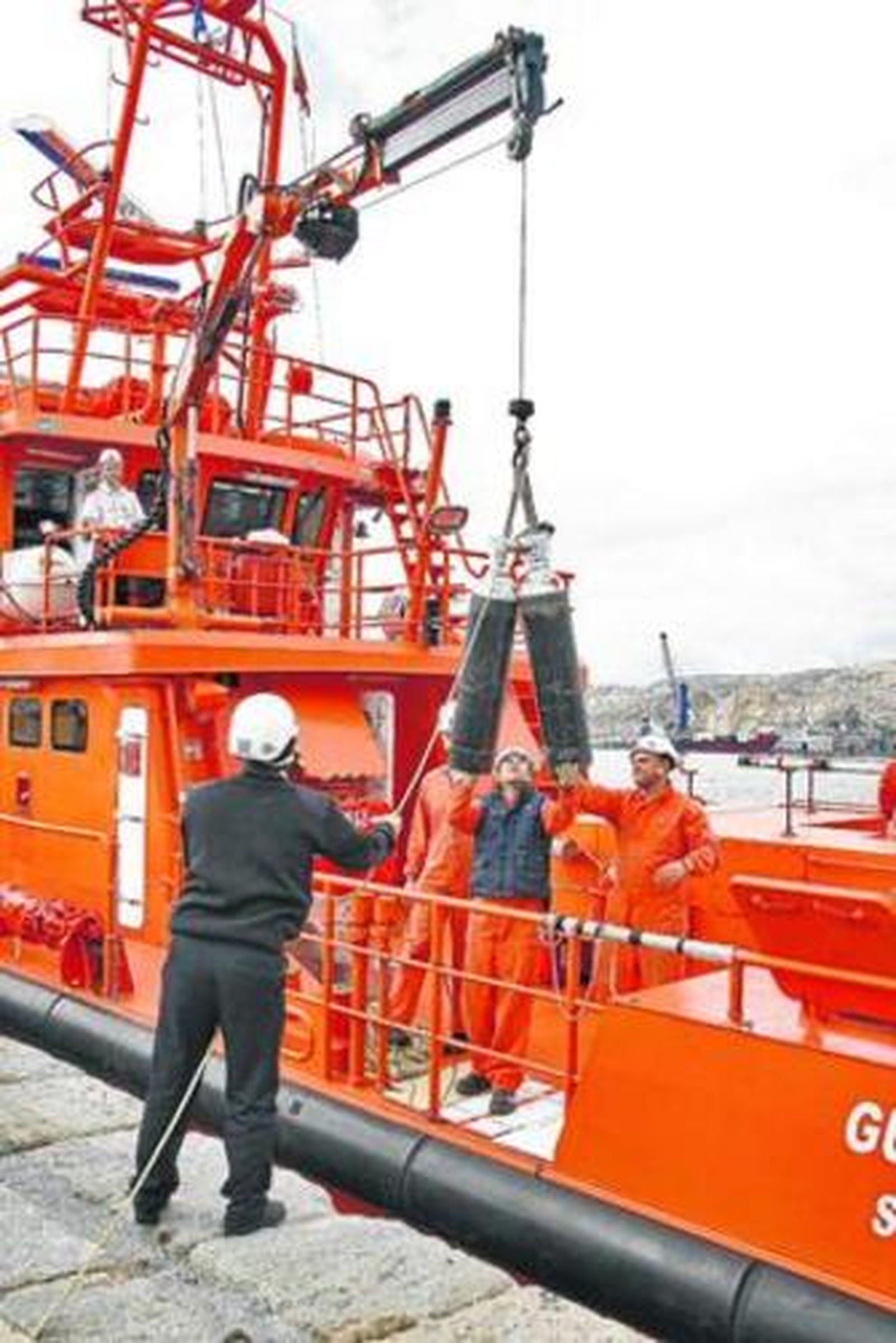 Efectivos  de Salvamento Marítimo transportan las bombonas de oxígeno.