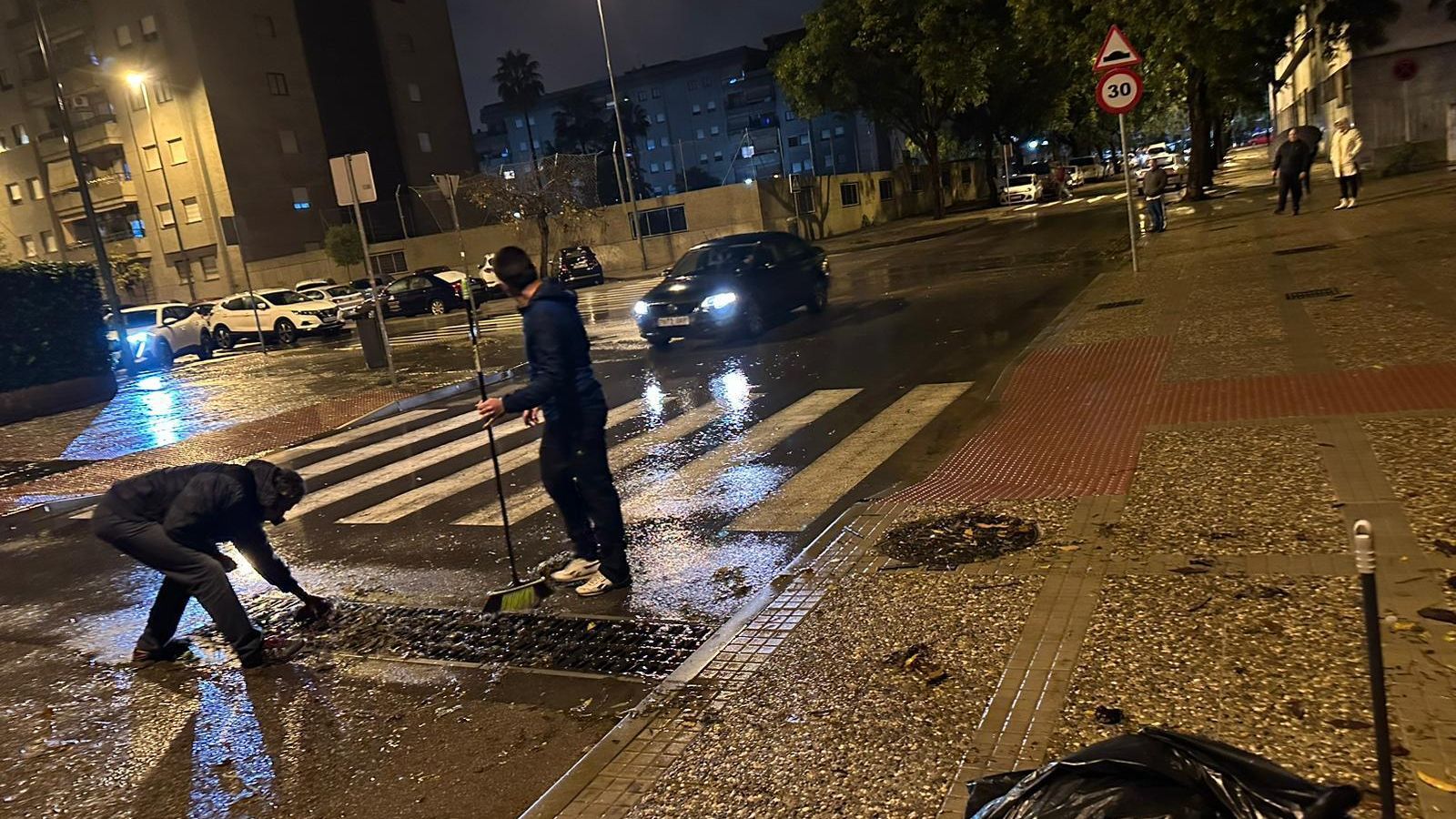 Vecinos de la urbanización Forum Chapín limpiando alcantarillas para evitar que el garaje se inunde.