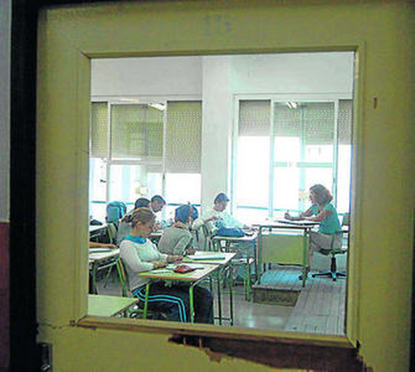 Adolescentes reciben clase, impartida por una profesora.