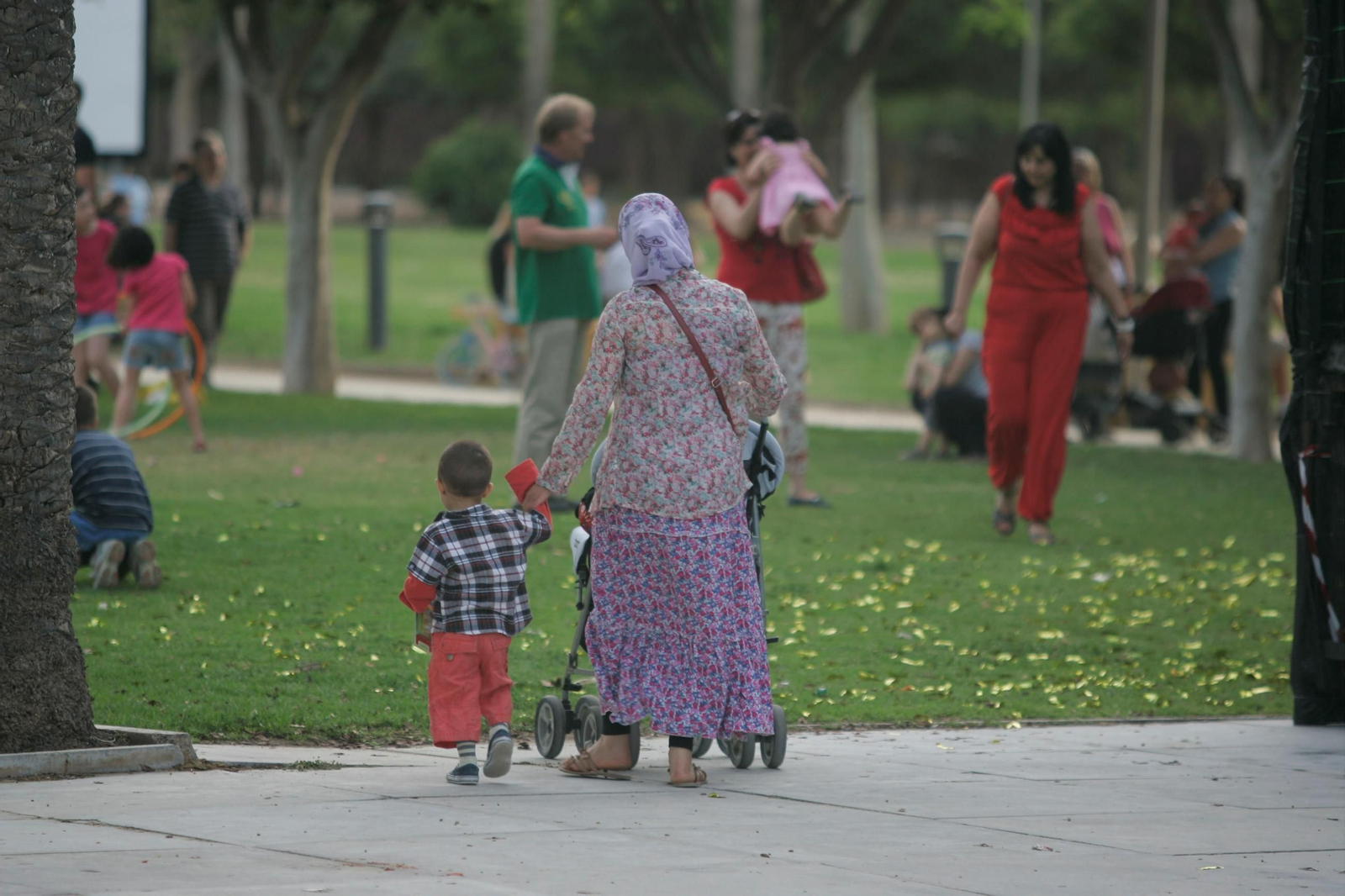 Una mujer camina de la mano de su hijo por las calles de la ciudad.