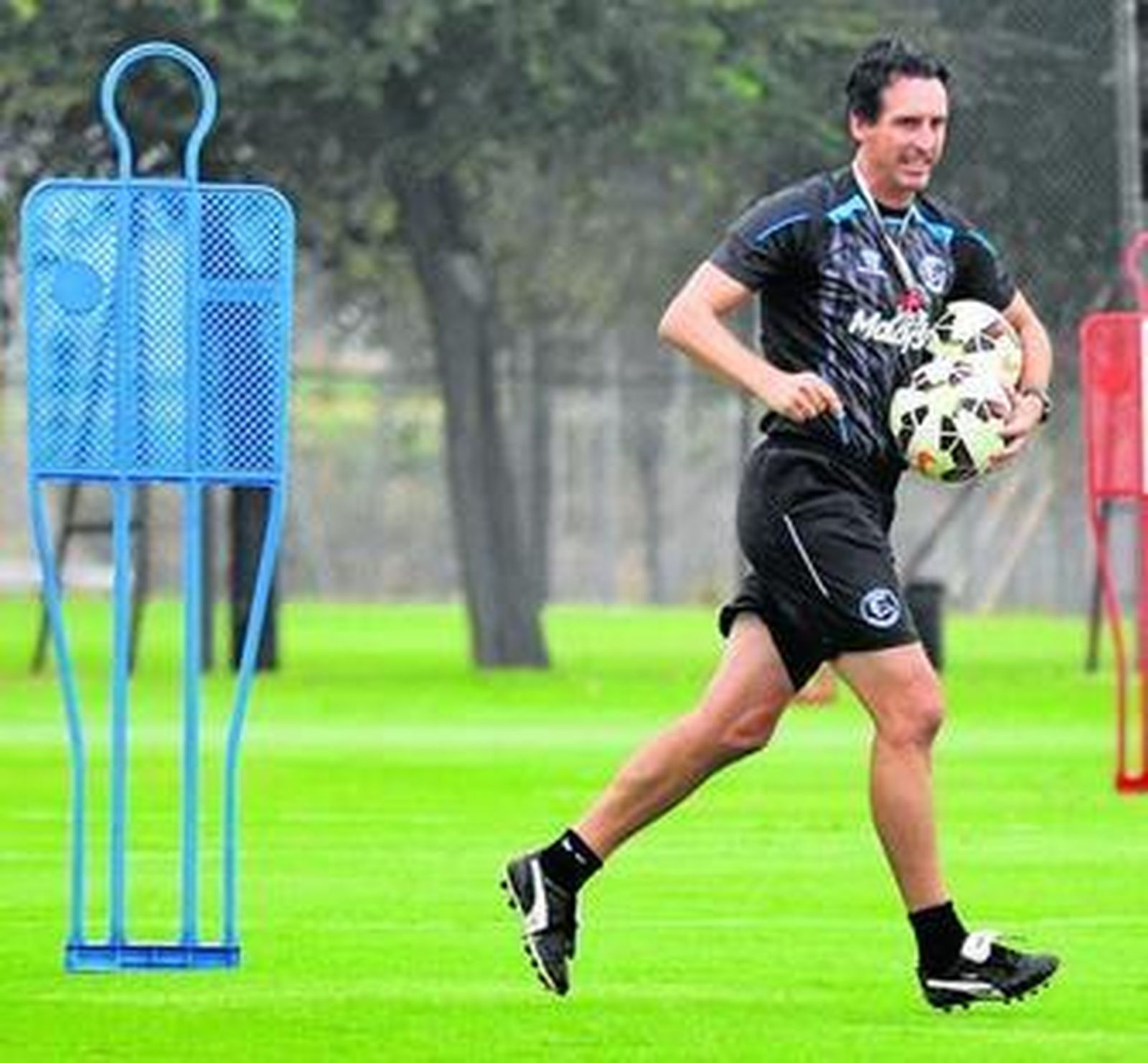 Emery corre con dos balones para preparar un ejercicio.