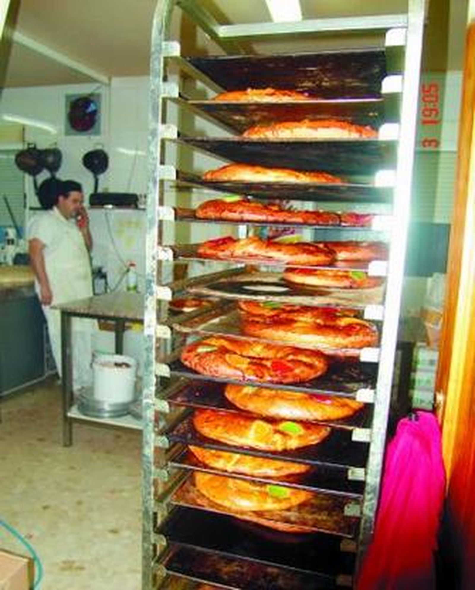 1. Los roscones, antes de ser rellenados. 2. Empleados y clientes de la peluquería brindan por el nuevo año y 3.Francis Vílchez, vigilando el horno.