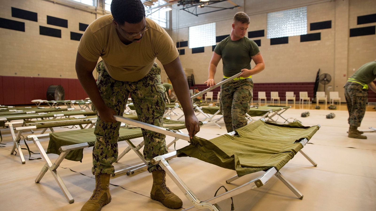 Marines estadounidenses colocan camas en el gimnasio de la base MCAS New River