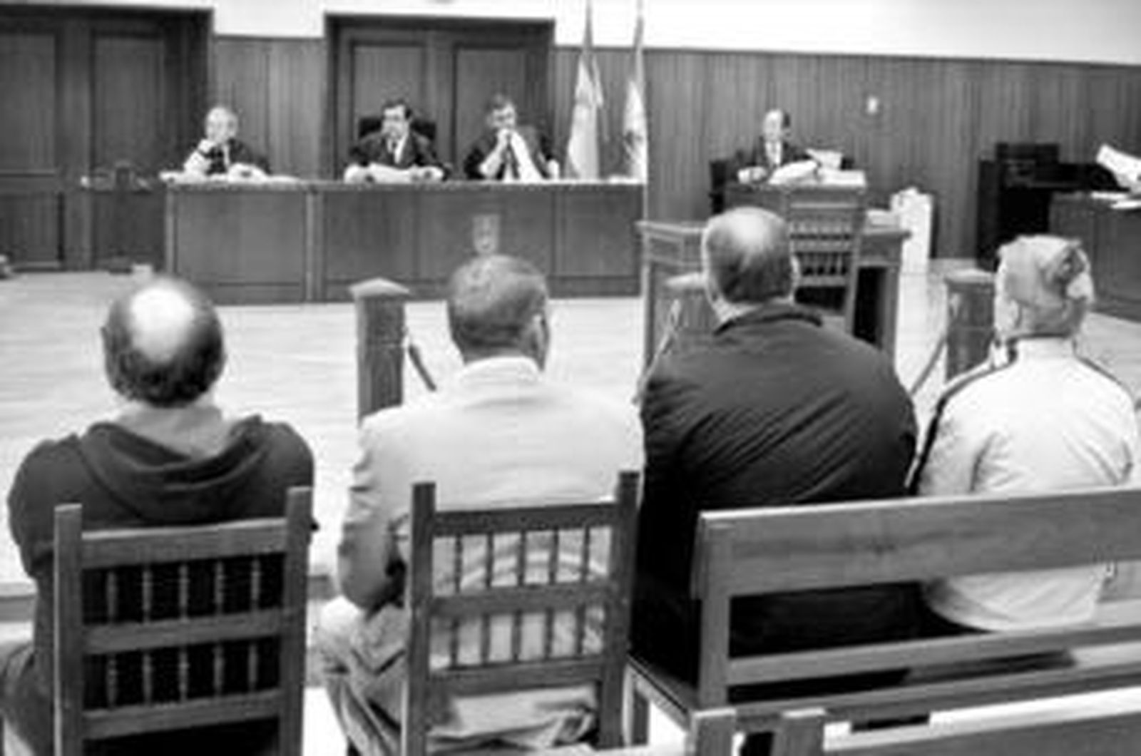 Los cuatro procesados, sentados en el banquillo de los acusados.