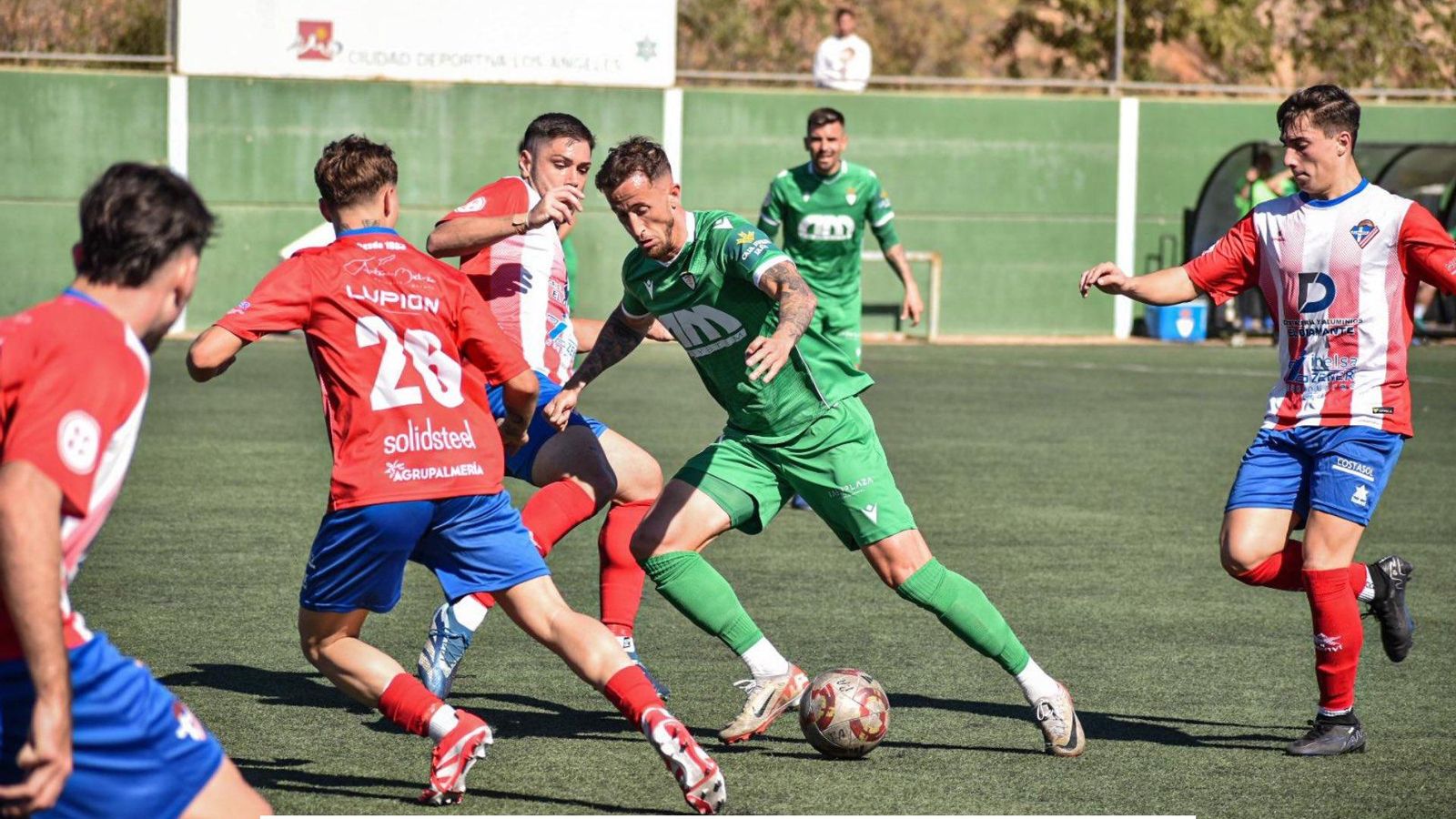 Varios futbolistas de conjunto rojiblanco tratan de arrebatar el balón a un rival.