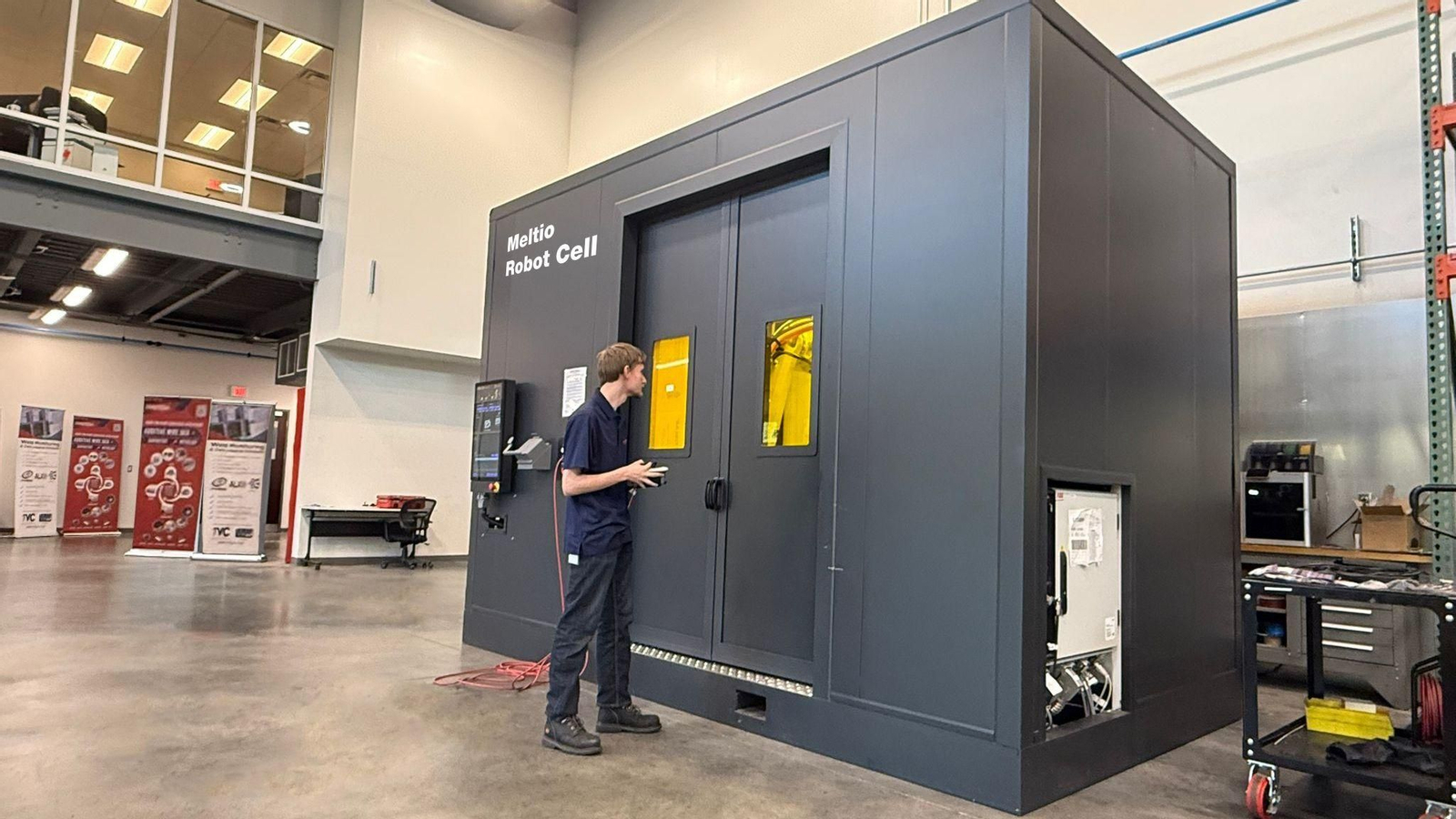 Un trabajador junto al Meltio Robot Cell.
