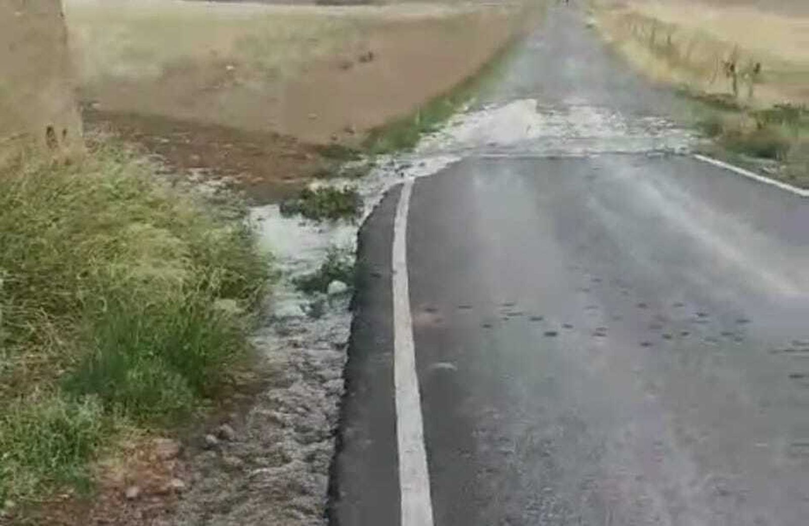 Imagen del agua salvando una carretera por la avería que sufren los depósitos.