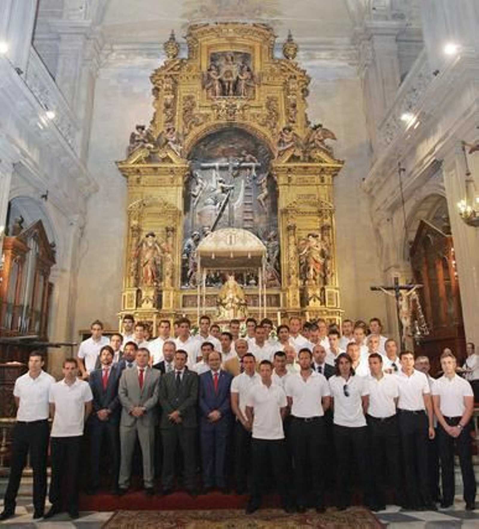 Miembros de la plantilla y directivos posan ante el altar de la Virgen de los Reyes.

Foto: Manuel Gómez