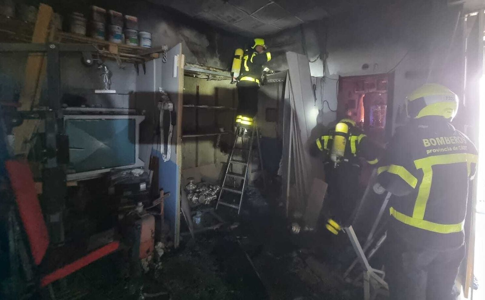 Los bomberos inspeccionan la nave de San Fernando incendiada.