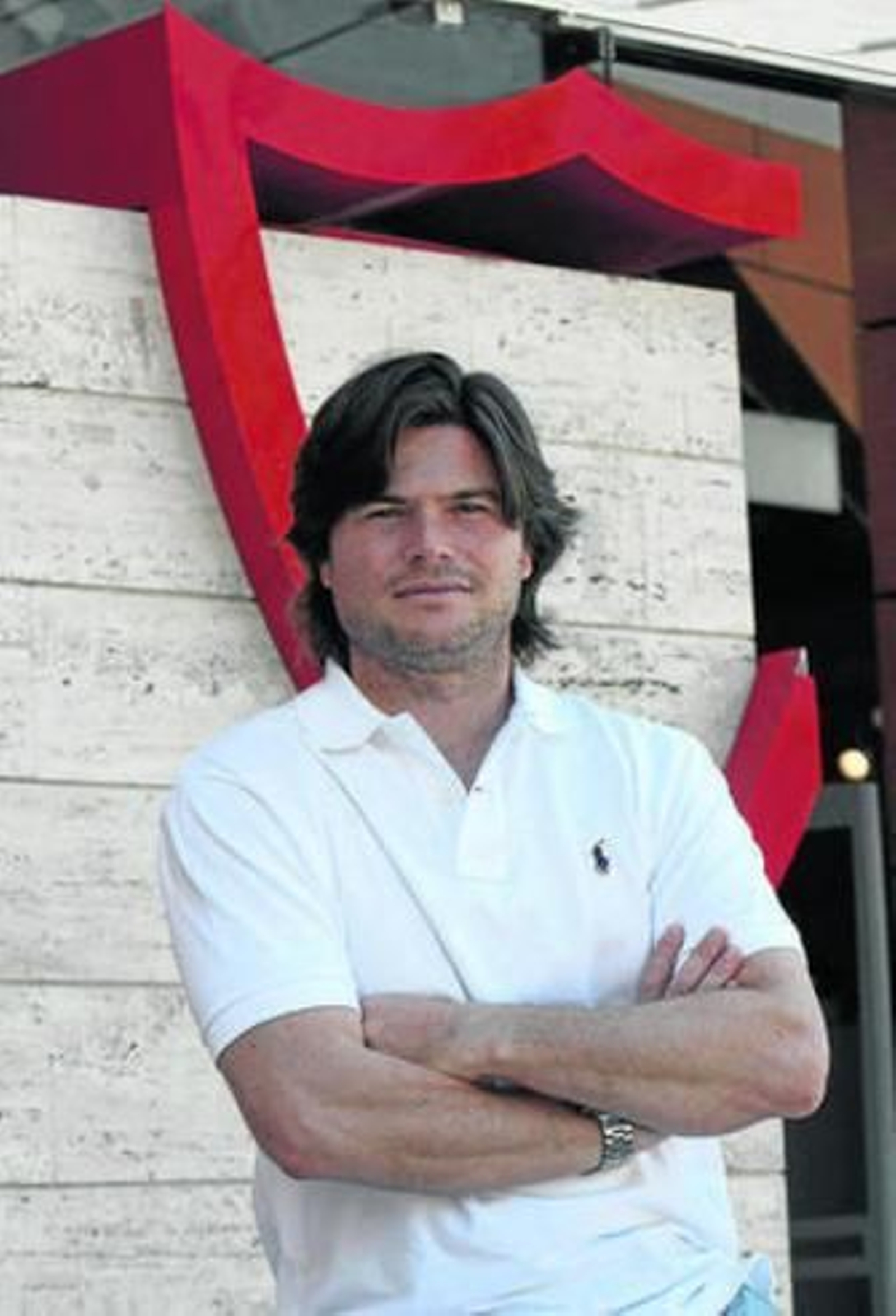 Agustín López posa junto a un escudo del Sevilla, en Nervión.