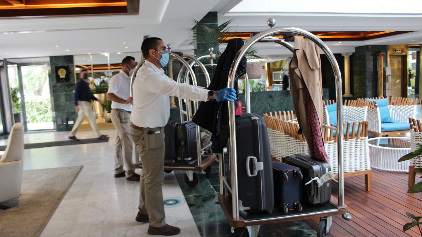 Conserjes recepcionan los equipajes de los turistas.