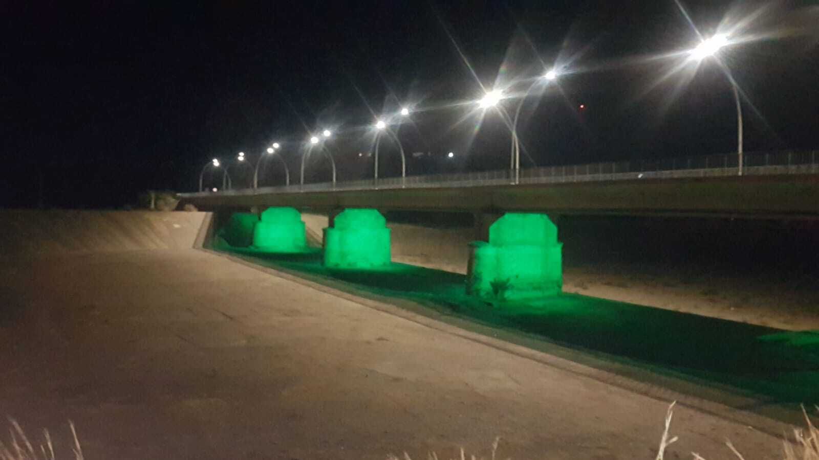 El puente de hierro de la localidad, iluminado de ver.