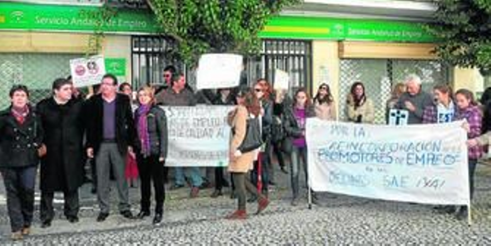 Los dirigentes del PP, junto a un grupo de trabajadores del SAE manifestándose.