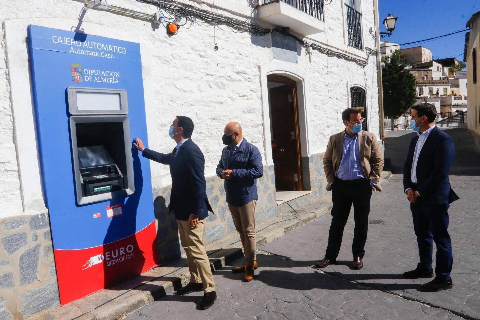 Javier Aureliano García junto al alcalde de Senes, Francisco Javier Sola, inspeccionan el cajero automático.
