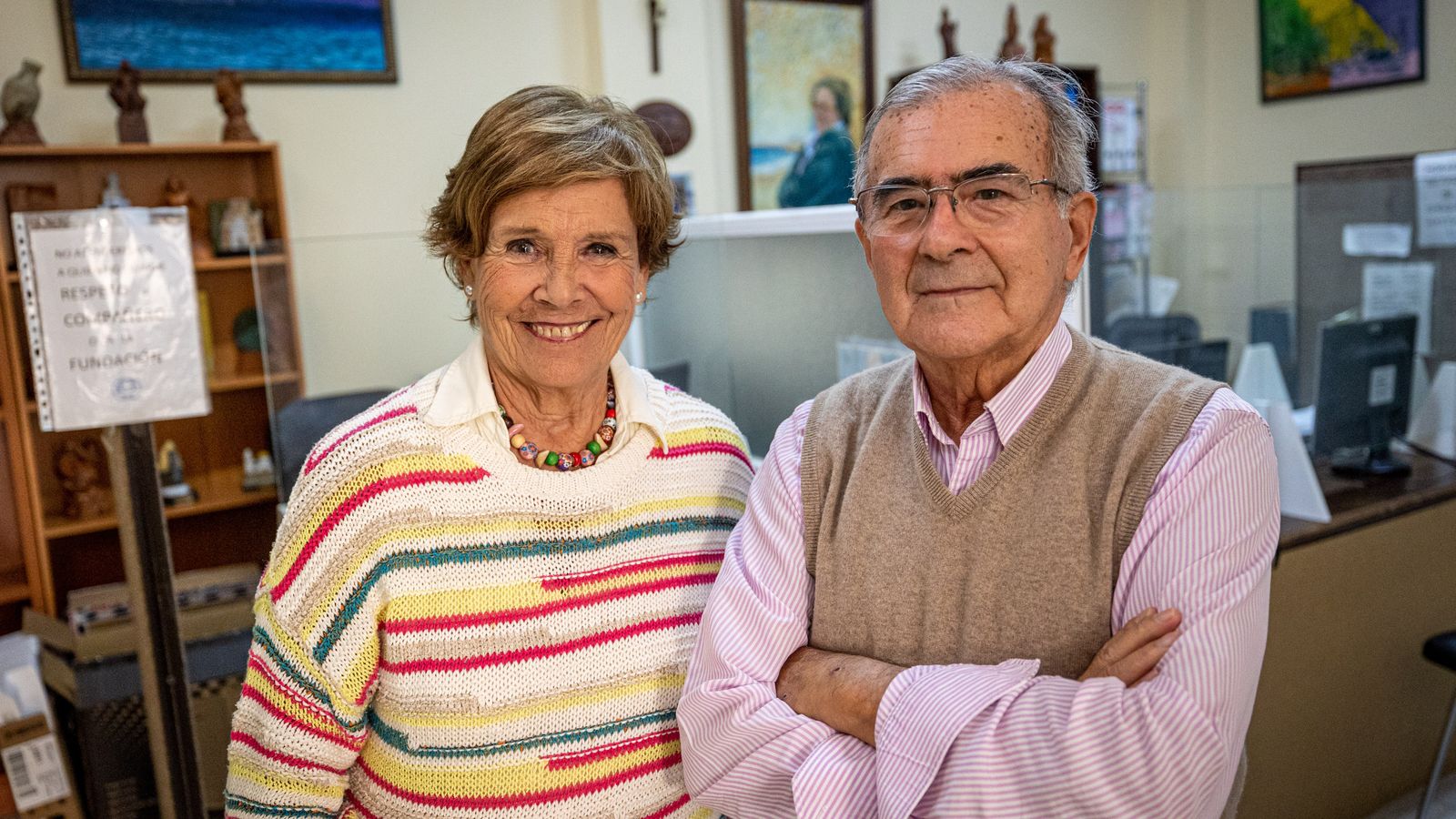 María Reyes y José Cuadrado, en la sede de la fundación, con un retrato de Dora Reyes detrás.
