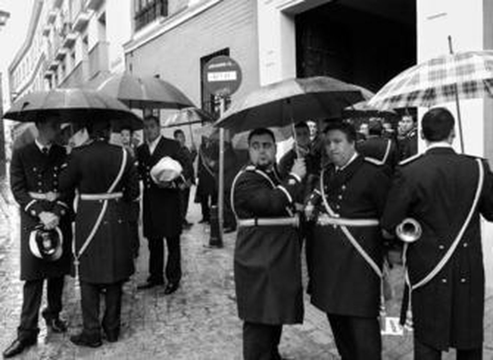 Los músicos de las banda de las Tres Caídas se refugian de la lluvia en las inmediaciones de San Martín.
