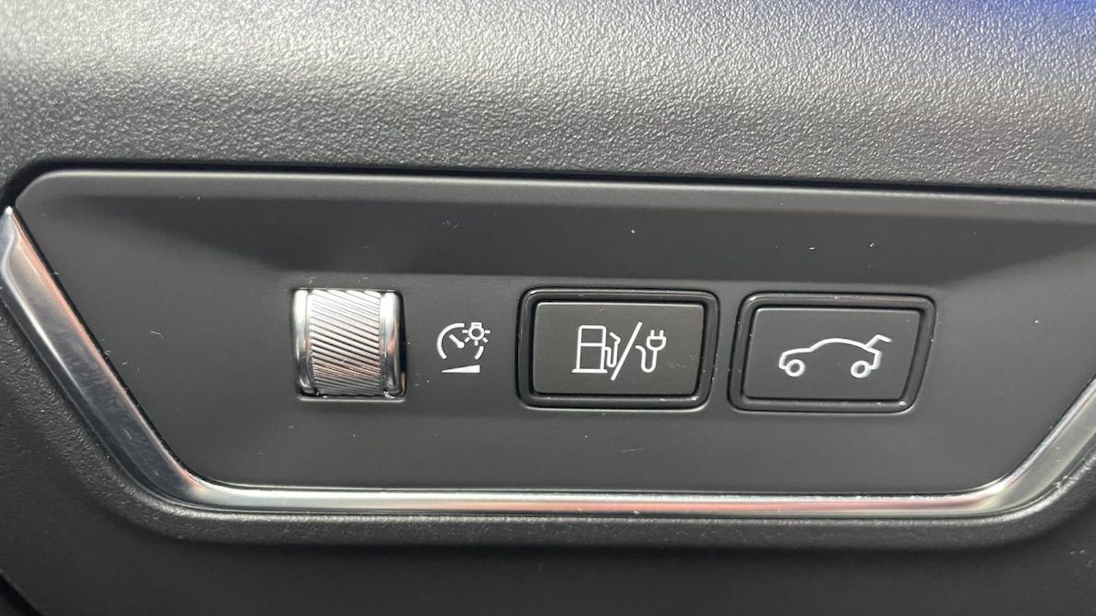 Esta tecla revela la condición de híbrido enchufable de este 01. Hay que mantenerla pulsada para que se abra la portilla del enchufe, situada en la aleta de la zona izquierda, oculta en la moldura decorativa.